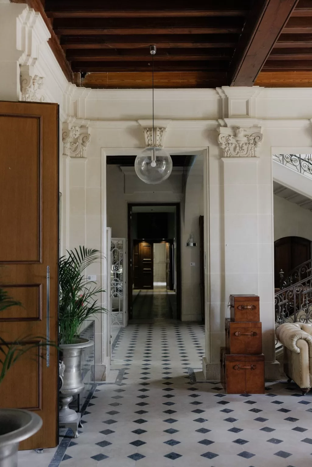 Elegant entrance hall at Château de Jalesnes featuring arched doorways, patterned flooring, and classic details.
