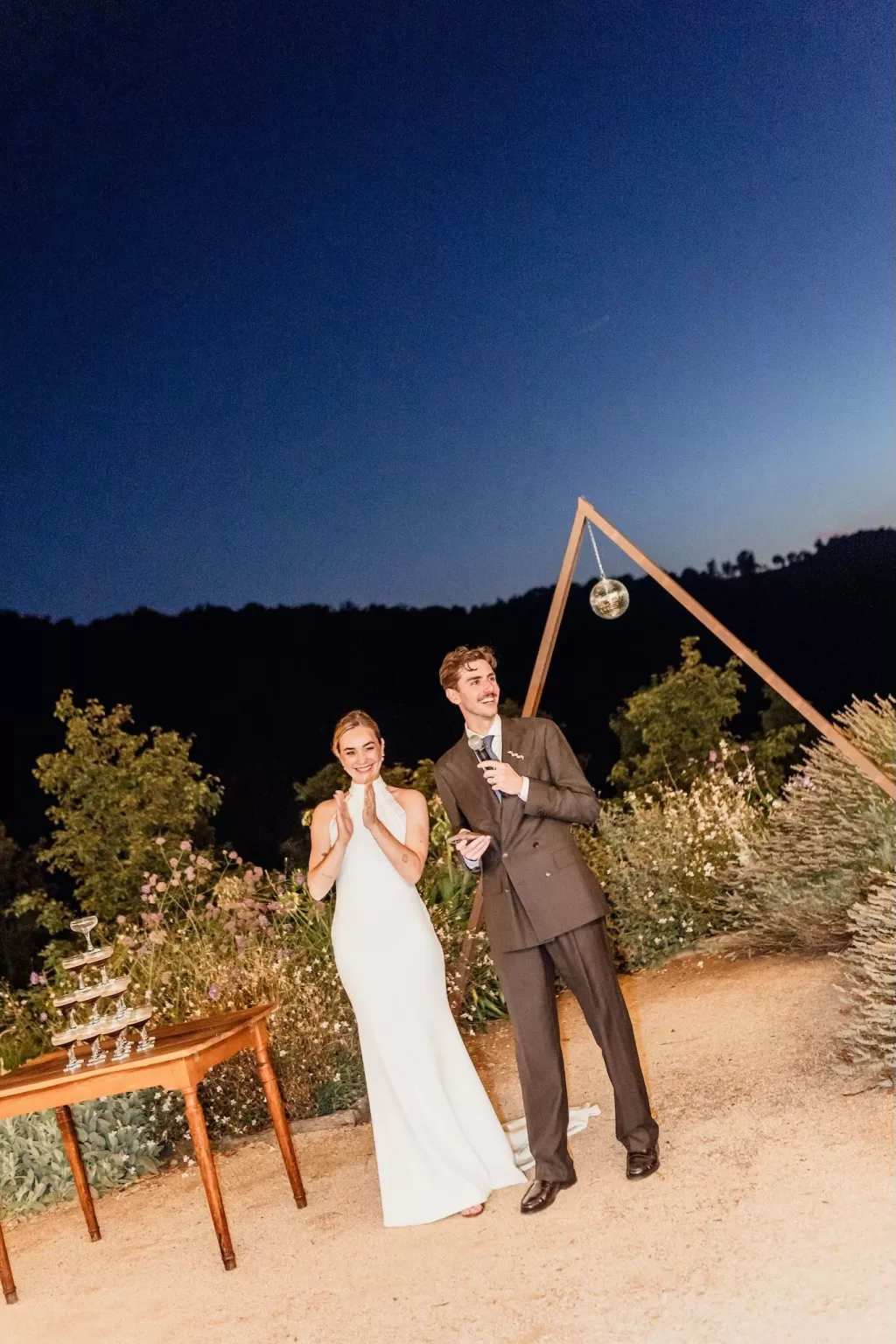 The couple share speeches under the night sky beside a champagne tower at This Must Be The Place.