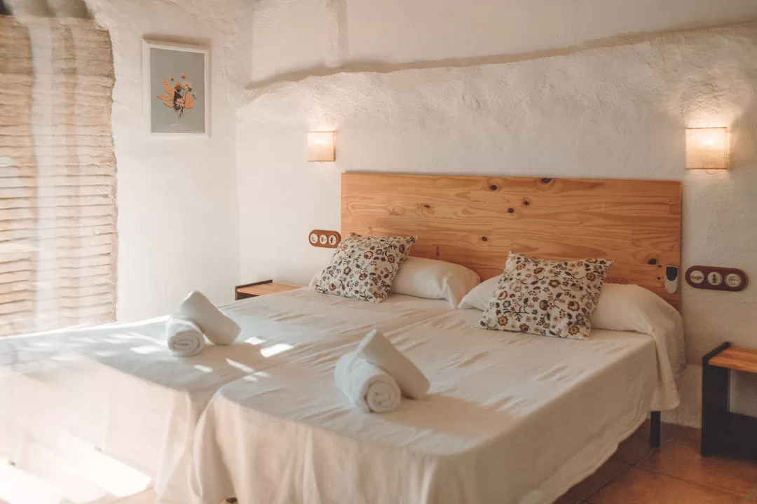 Warm Mediterranean-style bedroom at Masia Can Ramonet with natural wood details and soft light.