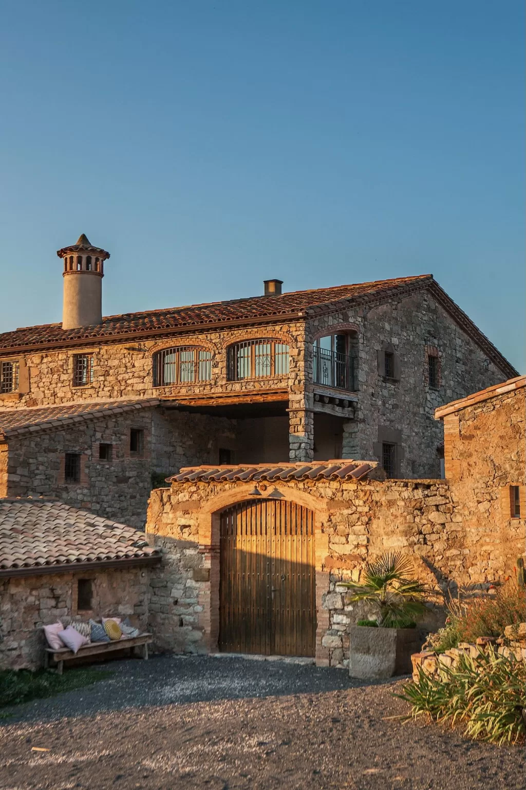 Close-up of the main entrance at This Must Be The Place, with wooden gates and soft golden-hour light.