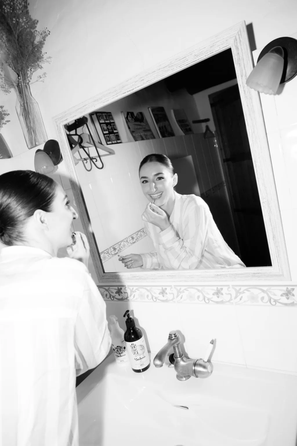 Bride applying lipstick in the mirror before her ceremony at This Must Be The Place, captured in black and white.