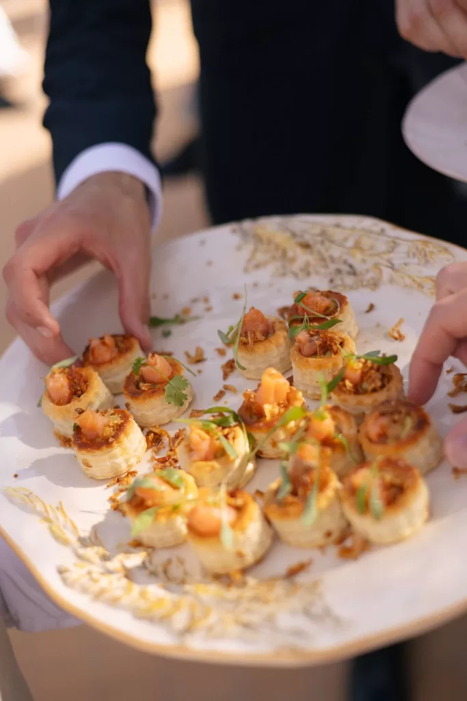 Close-up of elegant canapés being served at Casa Arte, with guests reaching for the beautifully plated bites.