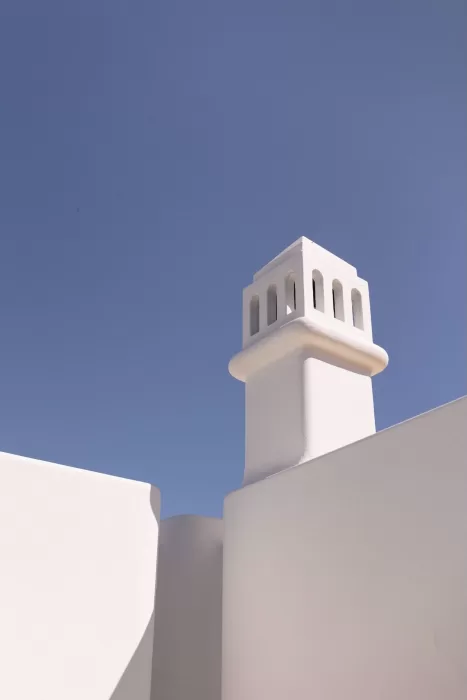 Sunlit white tower at Casa Arte set against a clear blue sky, showcasing the venue’s clean Mediterranean architecture.