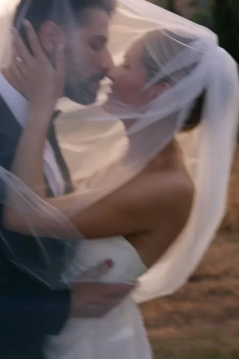 Romantic blurred portrait of the couple kissing beneath the bride’s veil at Casa Arte, capturing an intimate sunset moment.