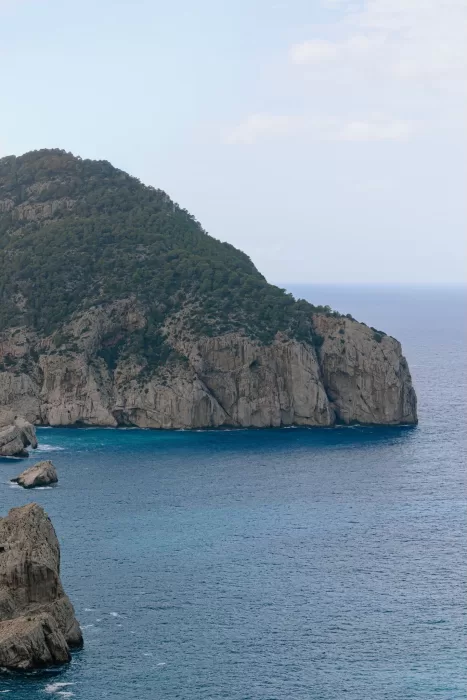 Panoramic view of the rugged cliffside and deep blue water surrounding Hacienda Na Xamena.