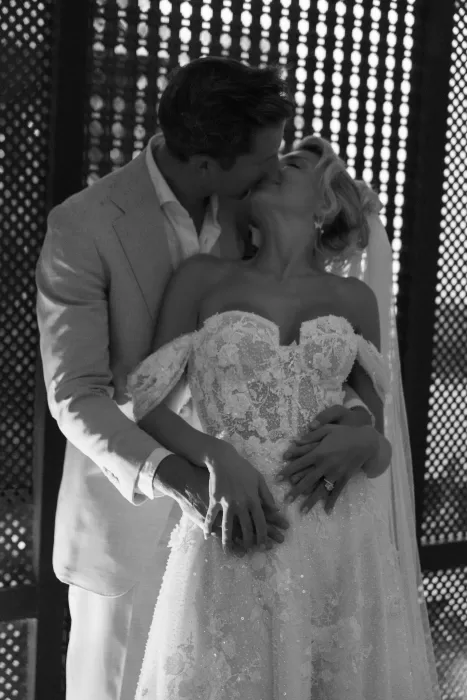 Romantic black-and-white moment of the couple kissing, with the bride’s lace bodice framed in soft shadows at Hacienda Na Xamena.