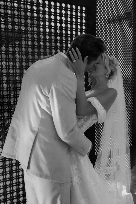 Close, emotional moment of the couple kissing in soft black-and-white lighting at Hacienda Na Xamena.