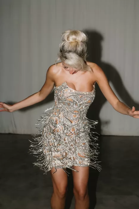 Bride in a shimmering beaded mini dress dancing during the evening celebration at Hacienda Na Xamena.