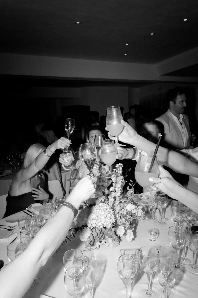 Guests raising glasses in a lively celebratory toast during the reception at Hacienda Na Xamena.
