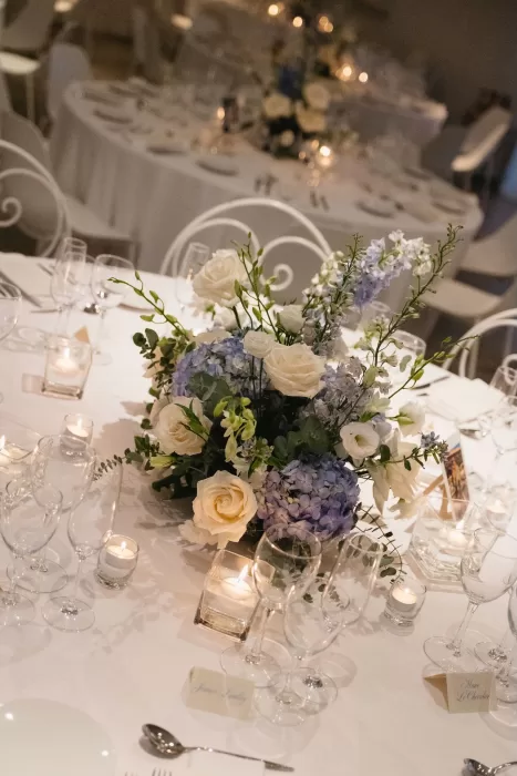 Elegant reception table with soft candlelight and blue-and-white floral centrepieces at Hacienda Na Xamena.