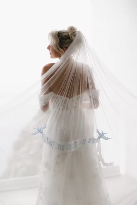 Bride standing in soft light with her embroidered veil flowing behind her at Hacienda Na Xamena.