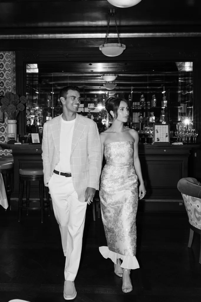 Elegant couple walking through the bar at Hotel Château Gütsch, dressed stylishly for an evening celebration.