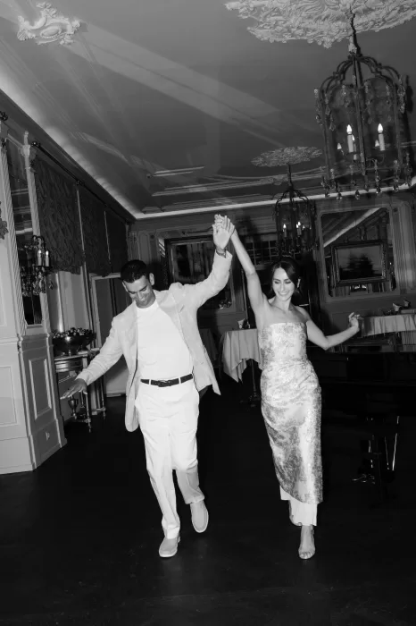Black and white image of a couple dancing together joyfully in the grand ballroom of Hotel Château Gütsch.