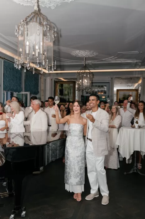 Couple raising a toast surrounded by guests during a celebration at Hotel Château Gütsch.