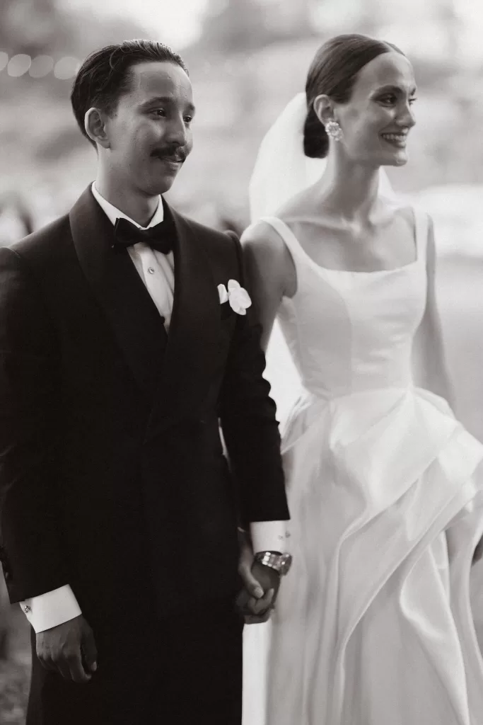 Bride and groom holding hands and smiling during their ceremony at Masseria Spina.