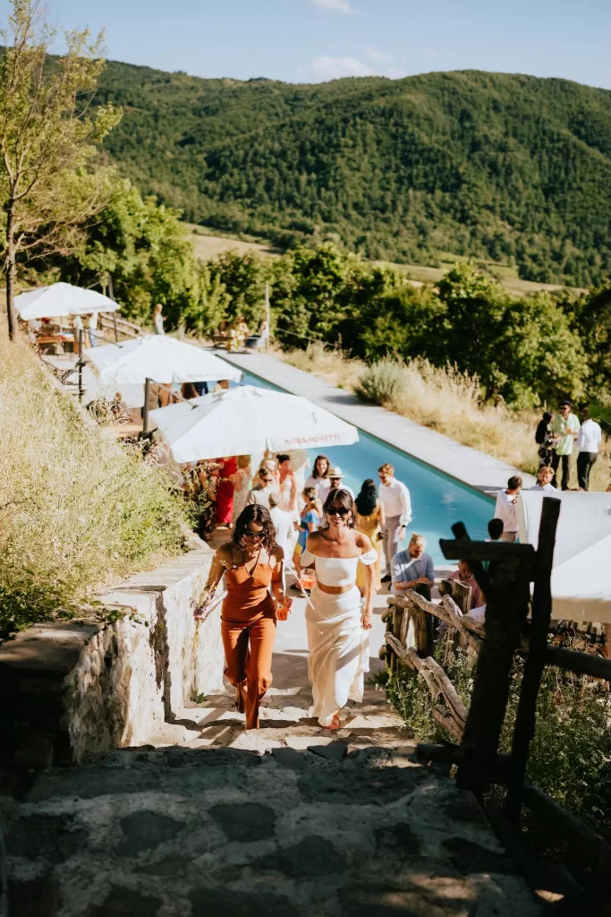 Guests enjoying a summer pool party at Novanta 90 surrounded by Tuscan hills and sunshine.