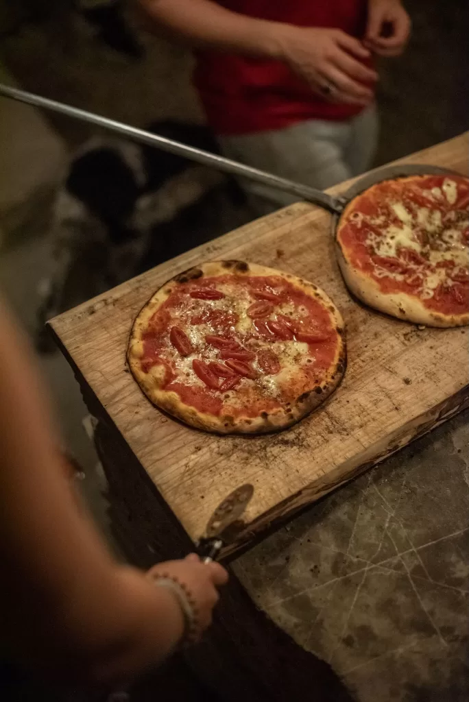Freshly baked wood-fired pizzas being prepared for guests at Novanta 90