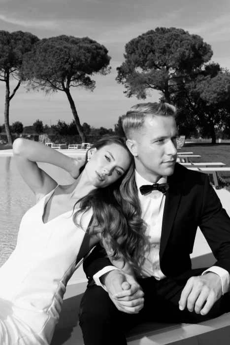 A stylish wedding couple relaxing beside the pool at Apulien Bari, captured in a soft, editorial black-and-white moment.