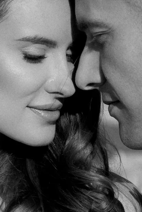 An intimate black-and-white close-up of the couple at Apulien Bari, their faces gently touching in soft natural light.