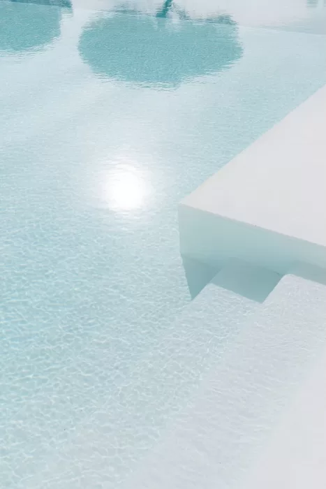 Soft sun reflections shimmering across the pale blue pool at Apulien Bari, creating a calm, minimalist scene.