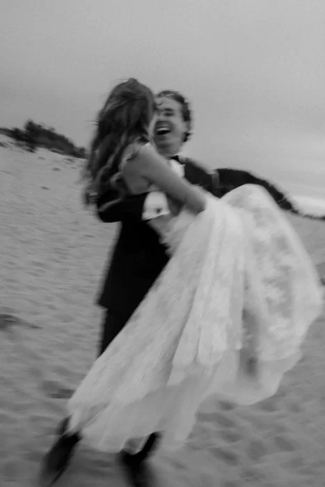 Bride and groom laughing together during a relaxed beach portrait session near Areias do Seixo.