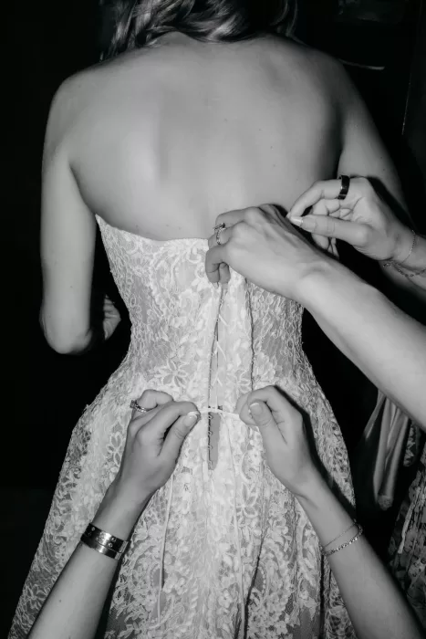 Close-up of the bride’s lace wedding dress being fastened during preparations at Areias do Seixo.