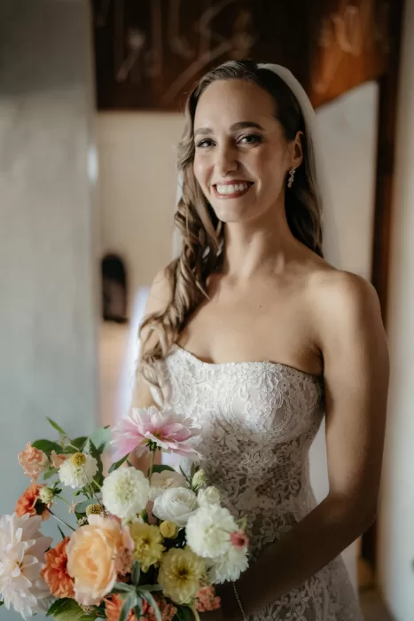 Bride holding a pastel-toned bouquet during bridal preparations inside Areias do Seixo.
