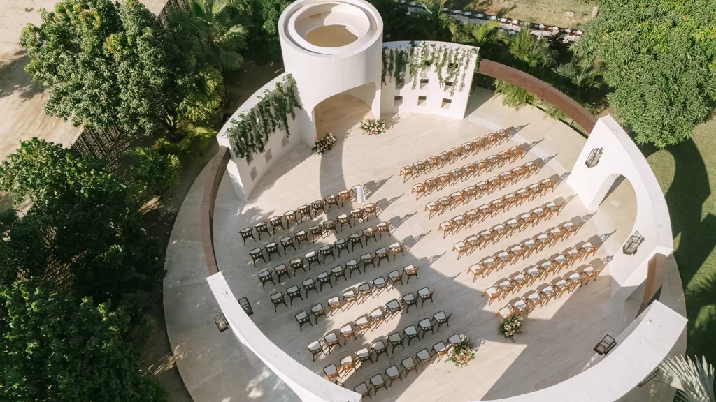 Aerial view of Baja Luna wedding ceremony space with curved white architecture and neatly arranged wooden chairs.
