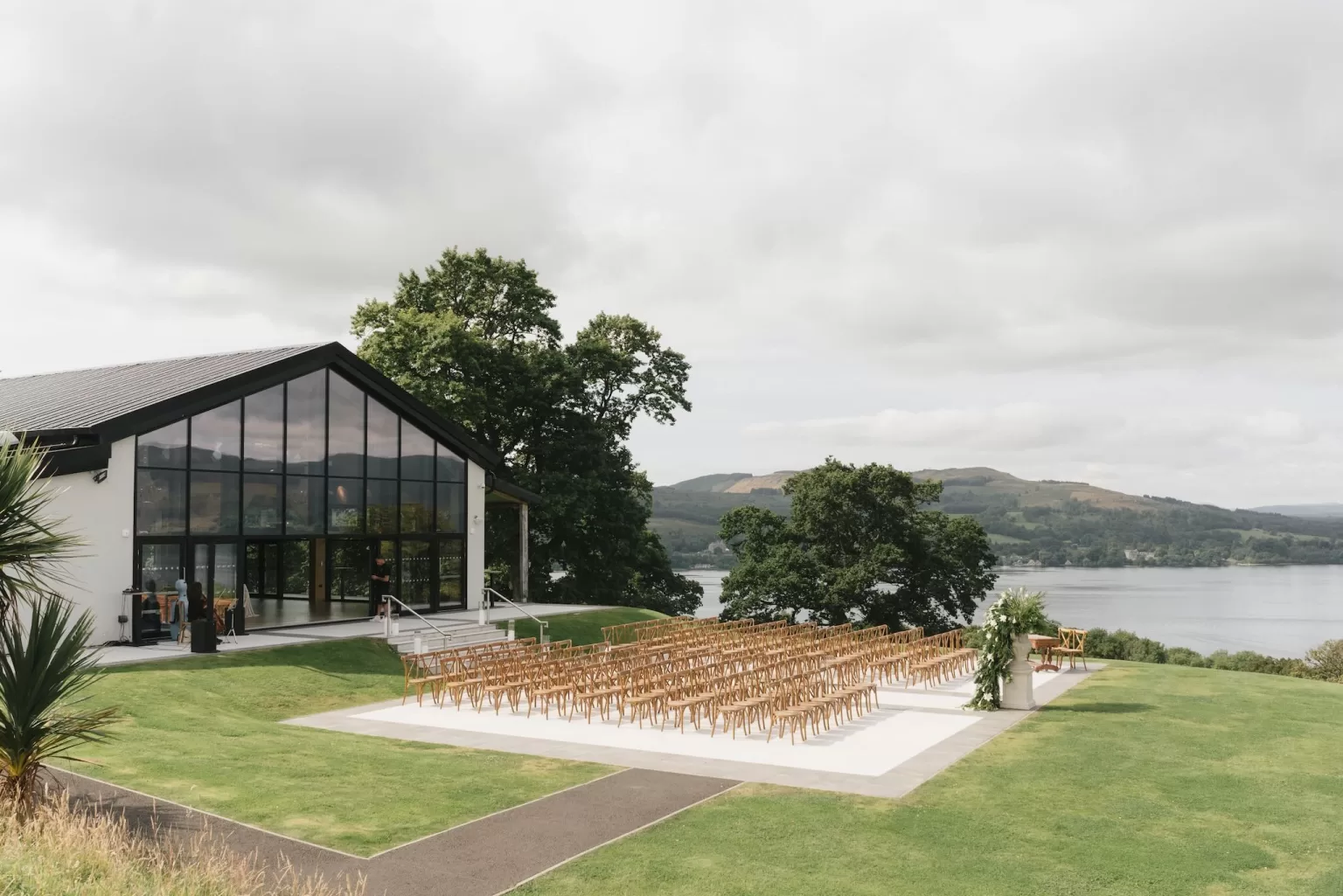 Outdoor ceremony space arranged on the lawn beside the modern pavilion at Boturich Castle.