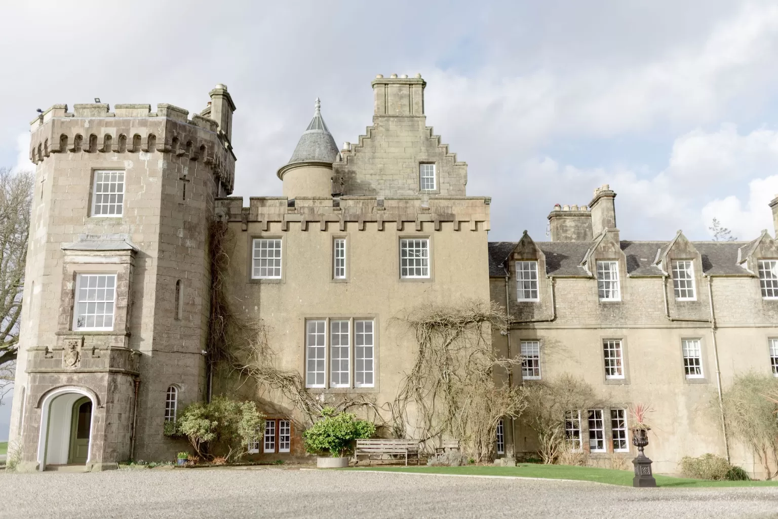 Exterior view of Boturich Castle showing its historic stone façade, turrets and formal architecture set within the Scottish countryside.