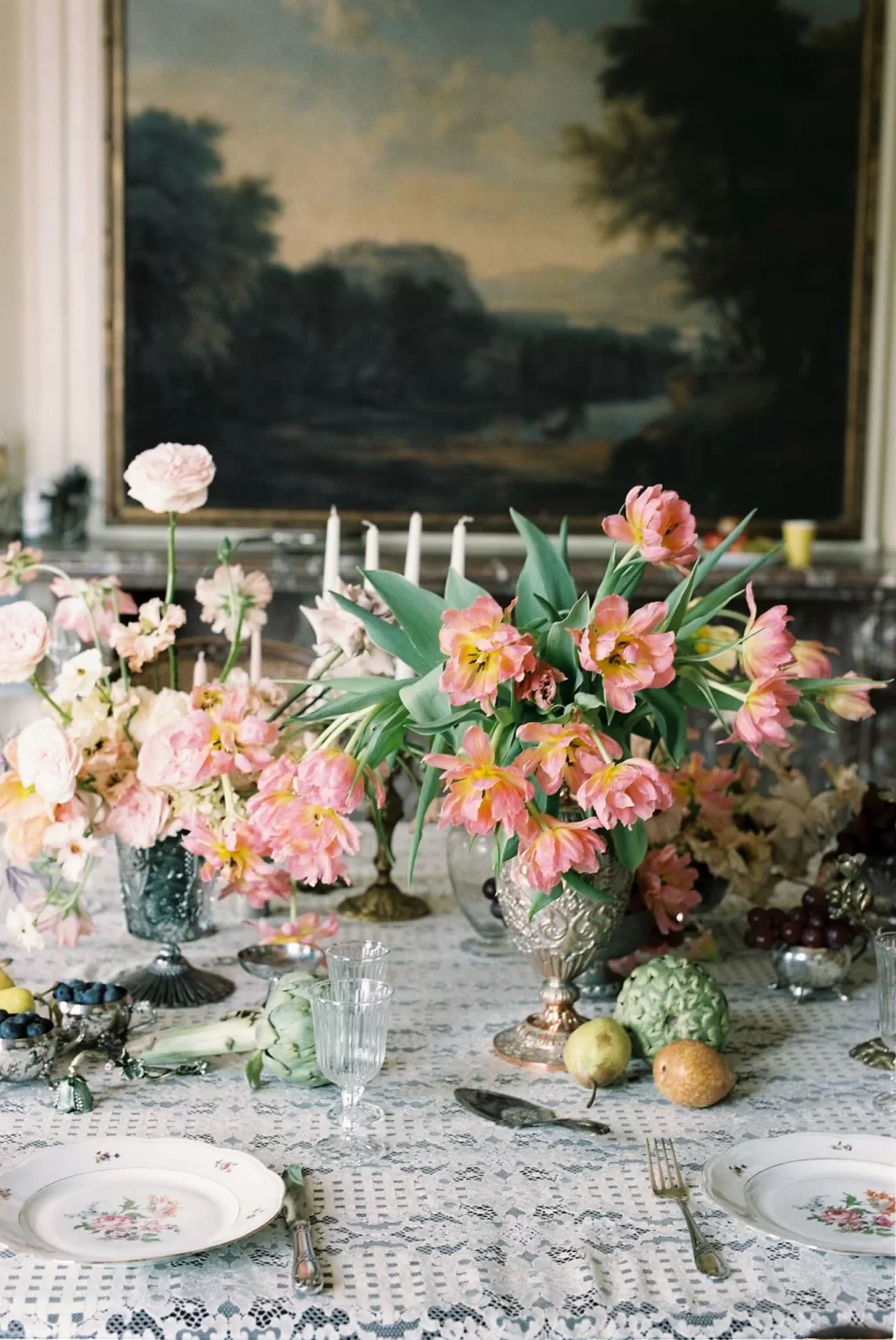 Lush pink florals and elegant fruit arrangements styled on a lace-covered dining table at Château du Prieuré.