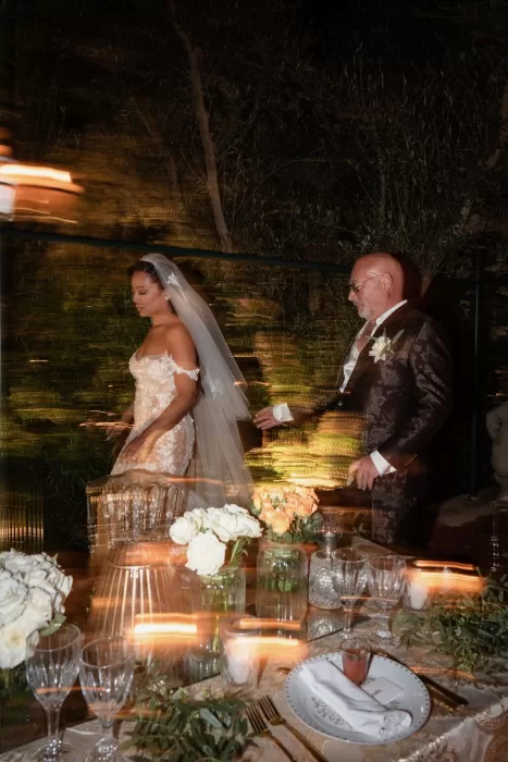 Bride and groom walking past candlelit dinner tables with motion blur capturing the evening energy at Jnane Tamsna.