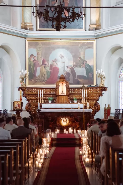 Candlelit wedding ceremony inside a historic church near Malpils Manor, creating a romantic and intimate aisle setting.