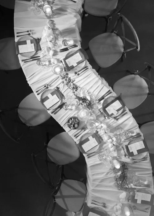 Overhead view of a long wedding table at Malpils Manor, showcasing flowing linens, candles and organic table decor.