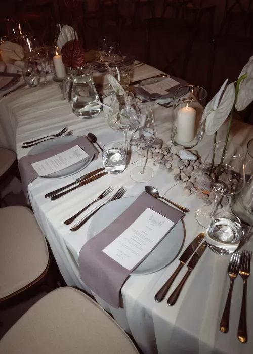 Elegant wedding table styling at Malpils Manor with soft linens, stone details, candles and minimalist place settings.