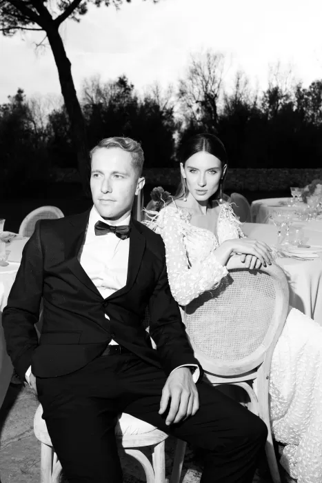 Dramatic black-and-white portrait of the bride and groom seated at their Masseria reception.