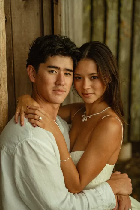 Close-up portrait of the bride and groom embracing beside the wooden walls of Ossipoff’s Cabin.