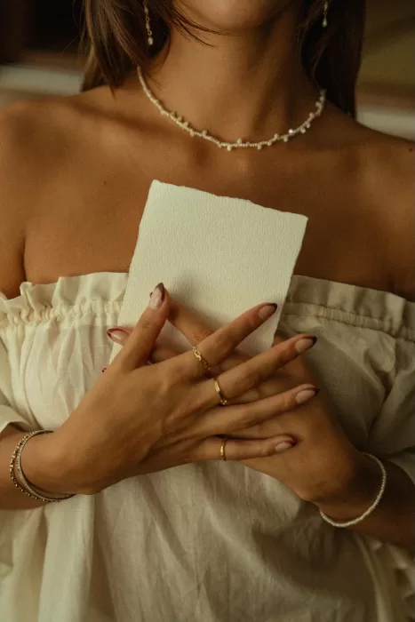 Close-up of the bride holding a handwritten love letter, highlighting quiet, personal wedding details at Ossipoff’s Cabin.