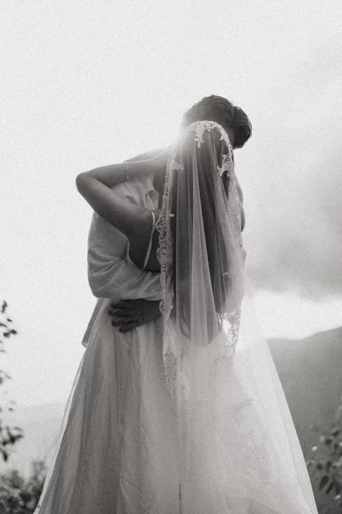 Black and white portrait of the couple embracing beneath a lace veil, creating a timeless wedding moment at Ossipoff’s Cabin.