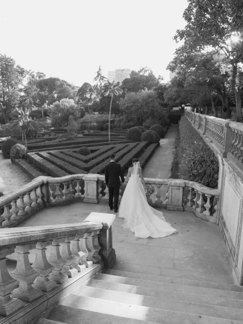 Newlyweds walking together through the formal gardens at Vandelli Botanical Garden in black and white.