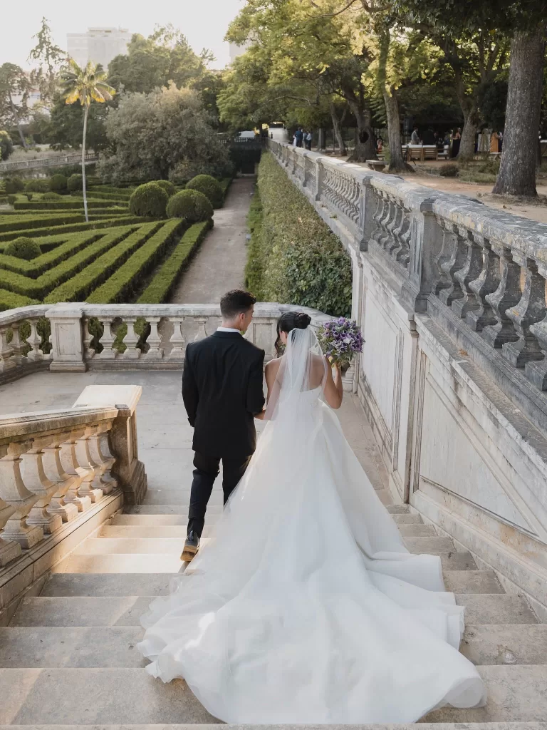 Bride and groom walking down the grand stone staircase overlooking the gardens at Vandelli Botanical Garden.