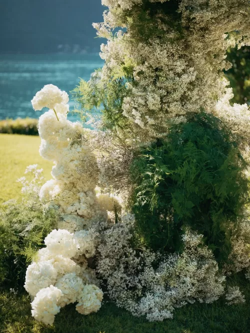 Floral ceremony installation with white blooms overlooking the lake at Villa Lario Resort
