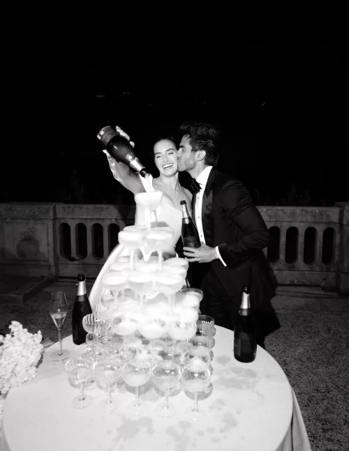 Bride and groom celebrating with a champagne tower during the wedding night at Villa Lario Resort