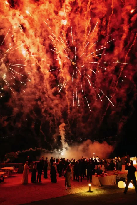 Guests watching dramatic fireworks over the lake during a wedding at Villa Lario Resort