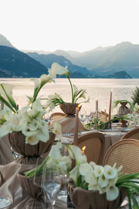 Elegant lakeside reception table with calla lily florals overlooking Lake Como at Villa Lario Resort