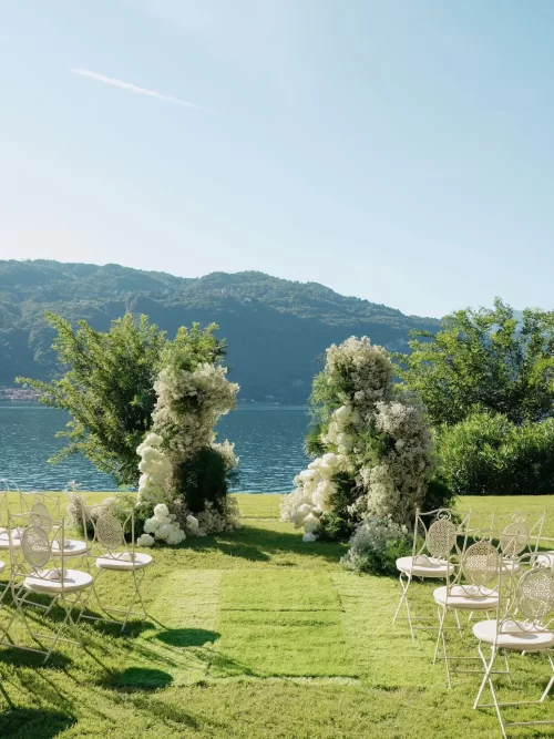 Lakeside wedding ceremony with floral columns at Villa Lario Resort