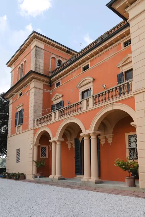 The terracotta arches and classical columns of Villa Lena’s façade glowing softly under the afternoon light.
