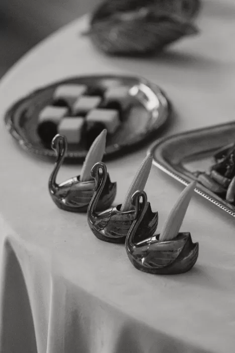 Close-up of refined wedding table details with sculptural serving pieces, photographed in a minimalist black and white style.