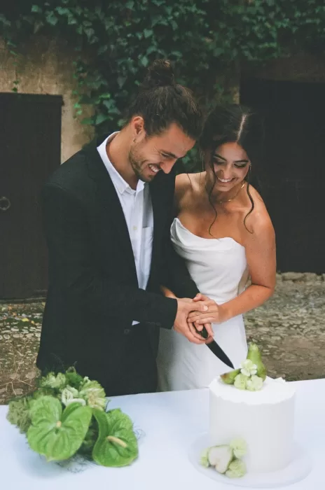 Couple cutting their wedding cake together in the courtyard of Finca Es Convent, captured in a candid moment.