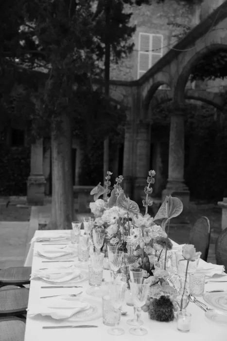 Black and white image of an elegantly styled wedding table beneath the cloisters at Finca Es Convent.